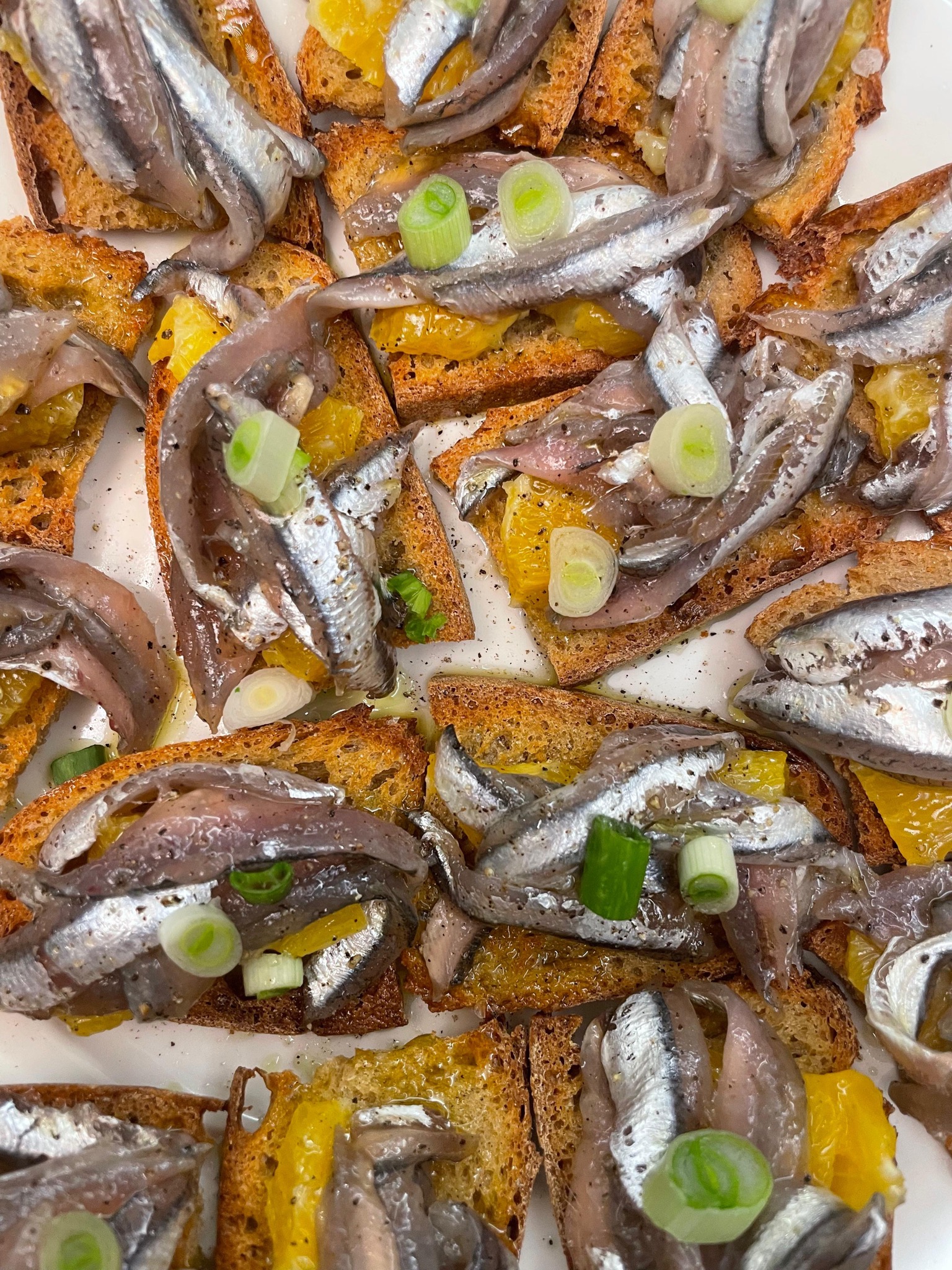 Anchovy bruschetta with orange and spring onion
